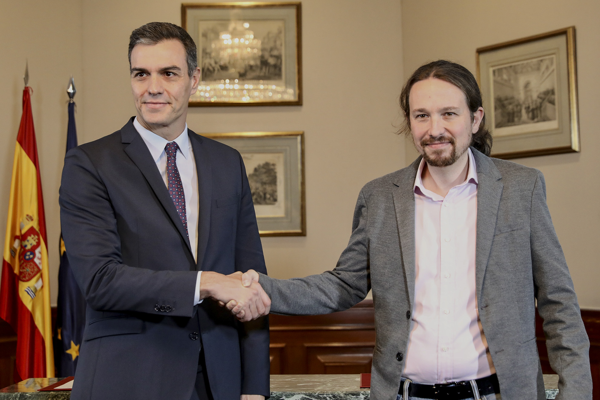 Pedro Sánchez y Pablo Iglesias estrechan las manos luego de firmar el acuerdo para la investidura presidencial de Pedro Sánchez. 