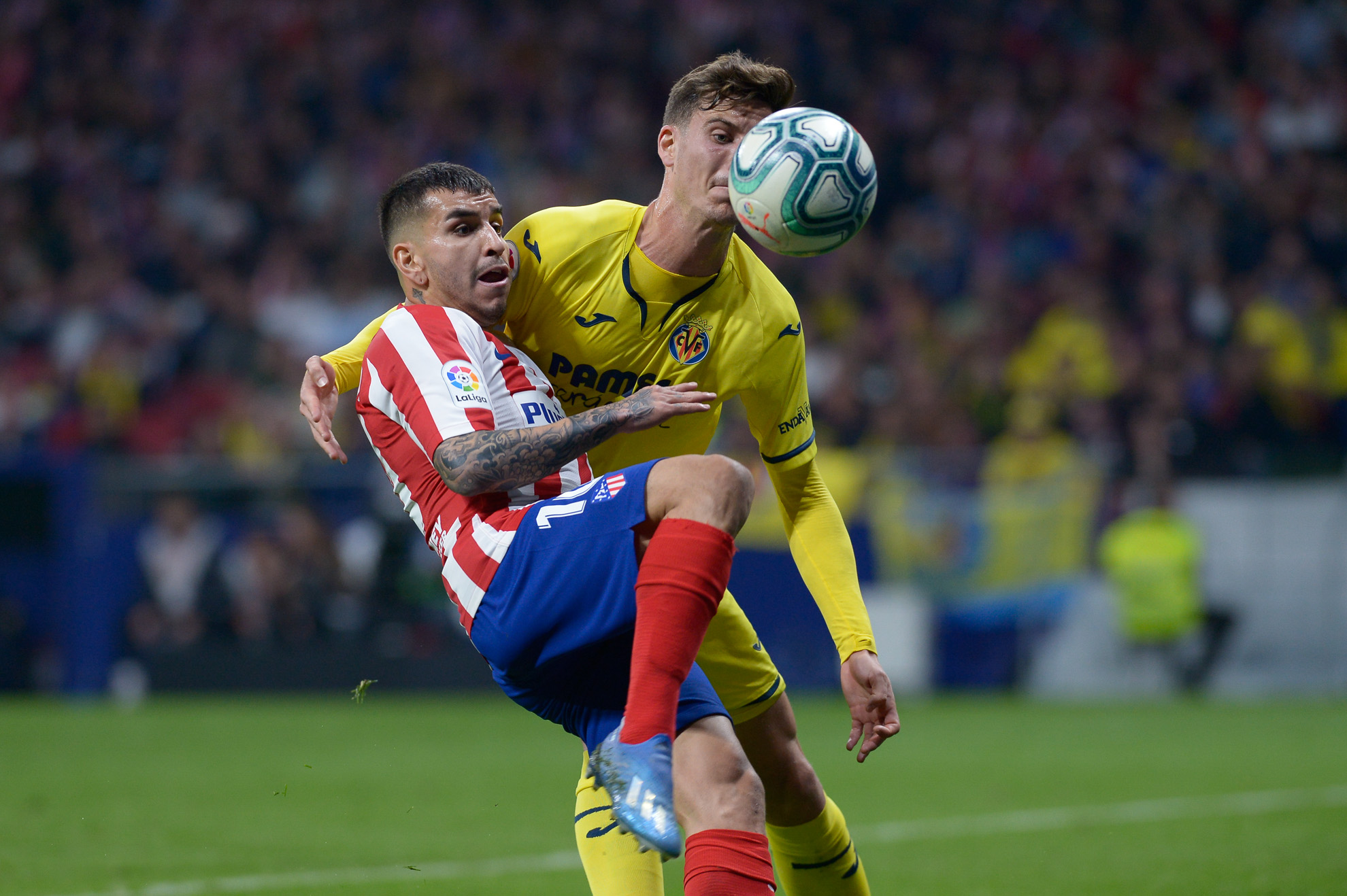 Ángel Correa y Pau disputan el balón durante el partido.