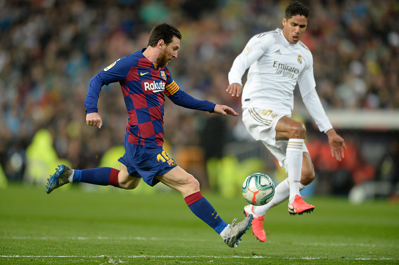 Varane y Leo Messi disputan el balón durante el derby español.