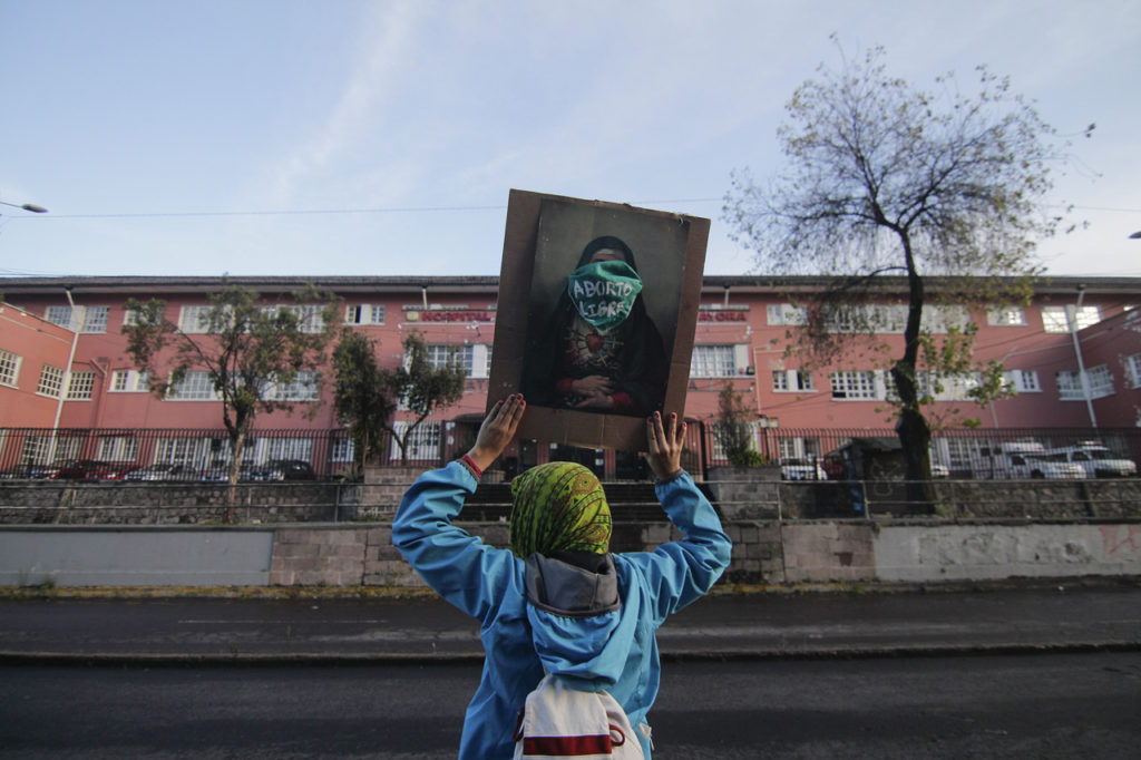 Una activista de los grupos feministas de Ecuador, muestra un cuadro de la Virgen de la Dolorosa con una mascarilla que reivindica el Aborto Legal y Seguro frente a la Maternidad Isidro Ayora en Quito