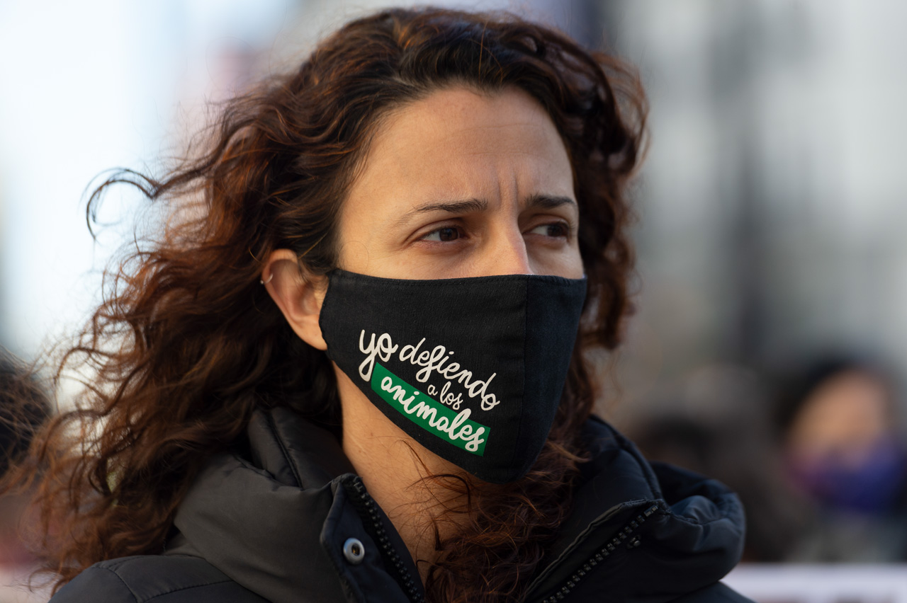 Una activista con un texto de yo defiendo a los animales en su mascarilla de protección por el COVID-19.