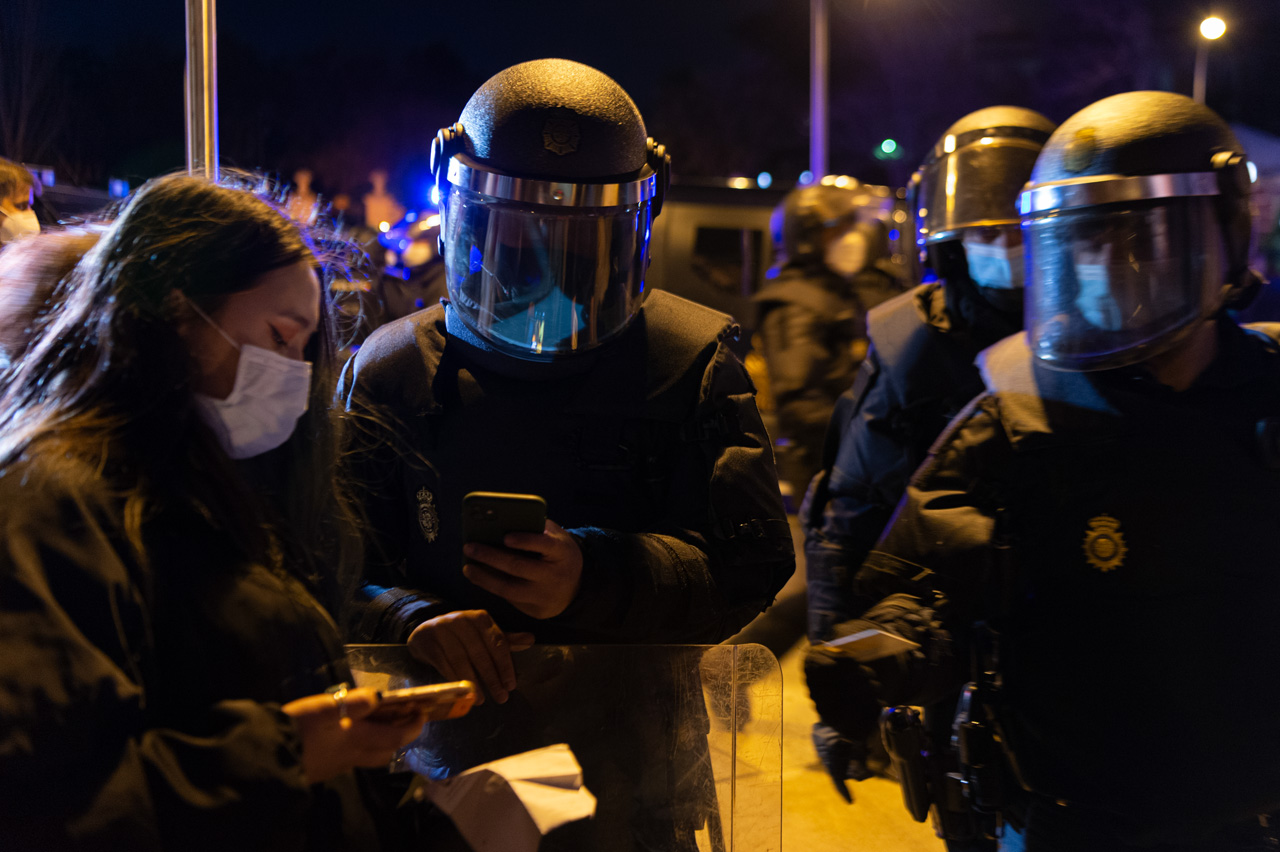 La policía española fotografía el DNI de una activista antifascista durante la protesta en Madrid.