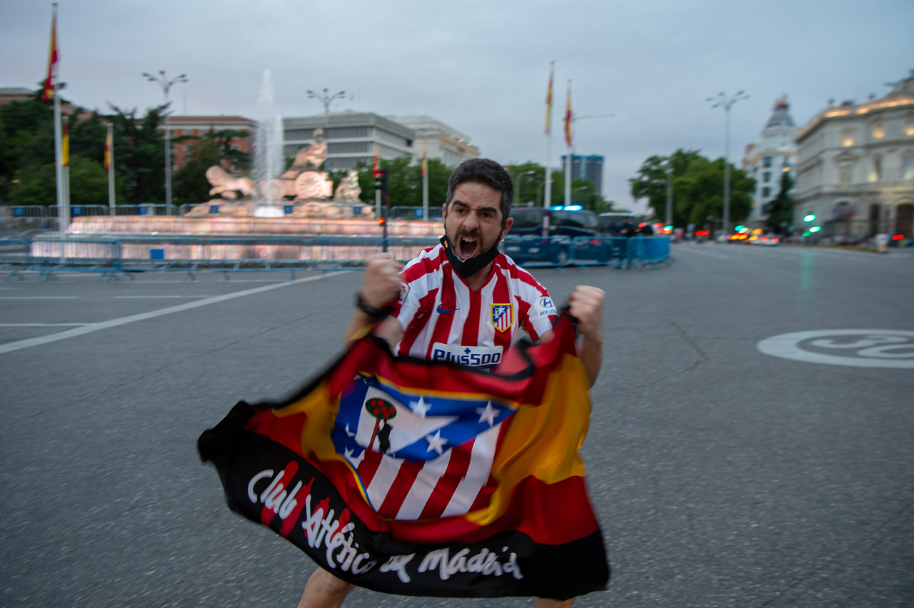 Un hincha del Atlético de Madrid festeja en la plaza de Cibeles el ser campeón de la Liga Española.