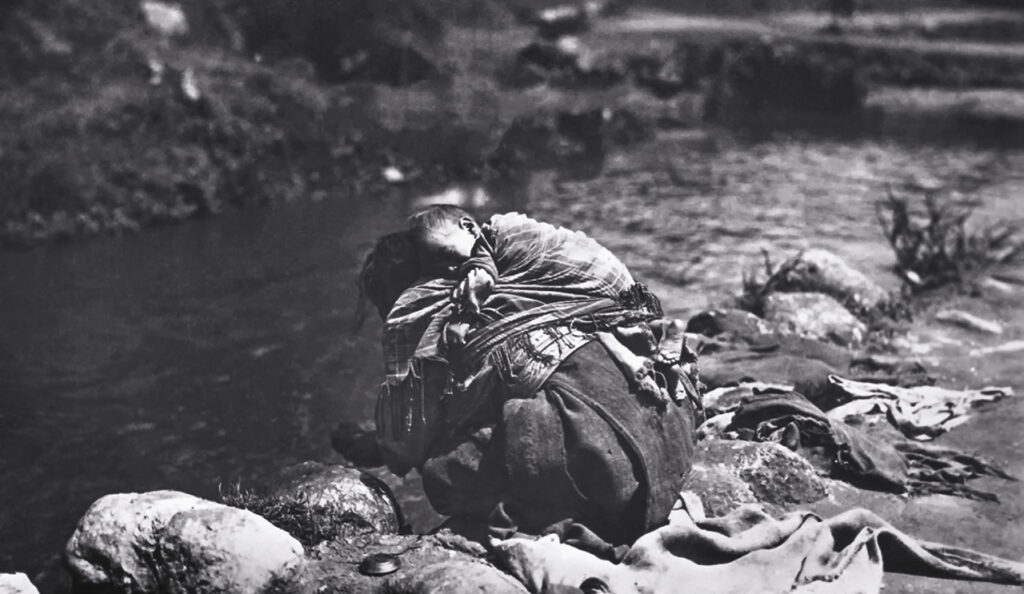 Mujer indígena lavando ropa en un río con su hijo, es parte de la investigación realizada por María Arboleda sobre el Indigenismo Perdido.