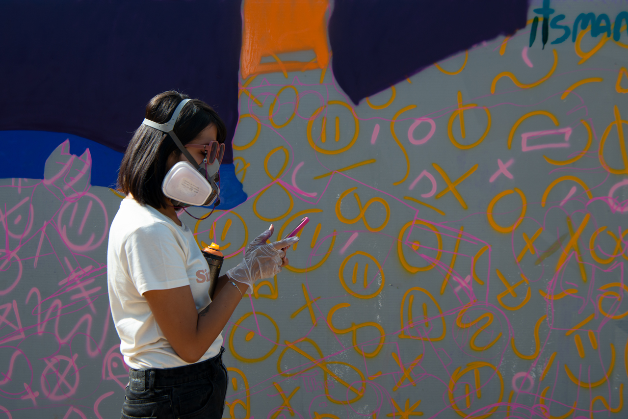 Mancho una de las artista del Arte Urbano del Graffiti, durante la transformación del espacio urbano de Matadero Pueblo bajo la mirada curiosa de los caminantes de Madrid Río.