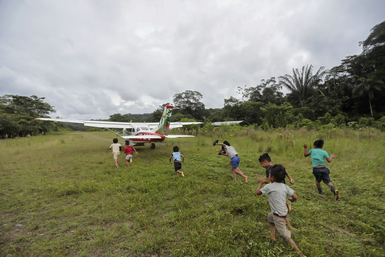 Niños corren detrás del avión Cessna T206H de la empresa Aero Sarayaku durante su regreso a Shell Aero Sarayaku la primera aerolínea indígena del mundo.