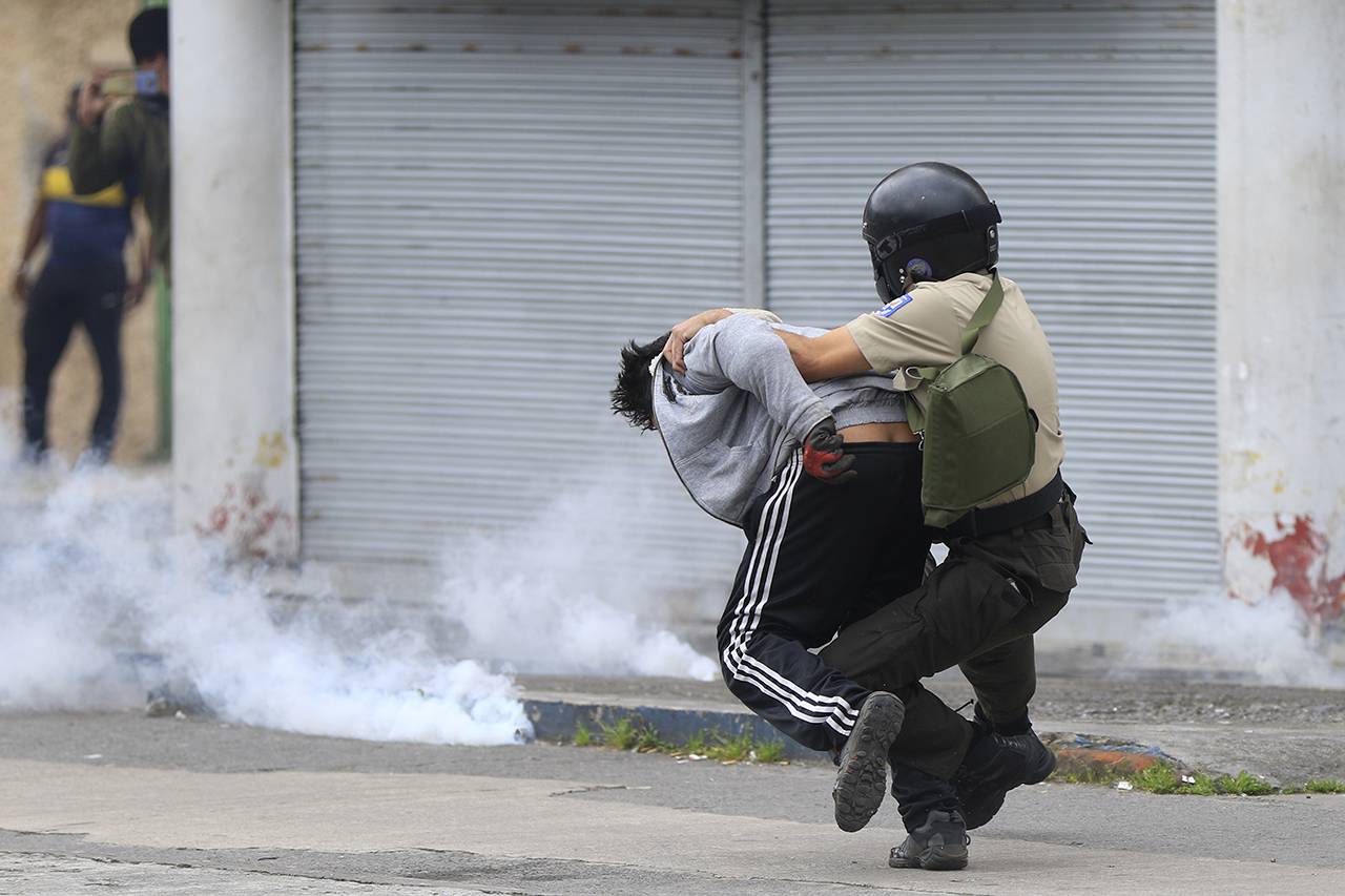 Un policía de Ecuador reprime a uno de los manifestantes en las protestas contra el gobierno de ultra derecha de Guillermo Lasso.