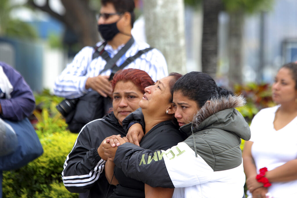 Los familiares de los reclusos asesinados lloran afuera de Medicina Legal y Ciencias Forenses mientras esperan noticias durante los disturbios en la penitenciaría de Litoral reciben sus restos en la morgue de la ciudad el 7 de octubre de 2022 en Guayaquil, ciudad de la Gobernanza Criminal.